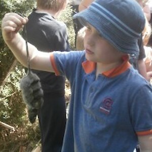 Liam bravely holds a dead rat caught in a trap