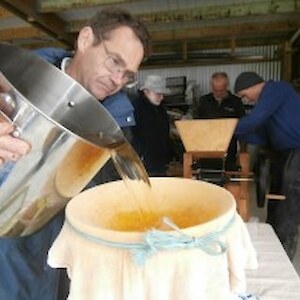Brian pouring clear pressed apple juice