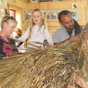 Janet, Emma and Chris weave the leaves